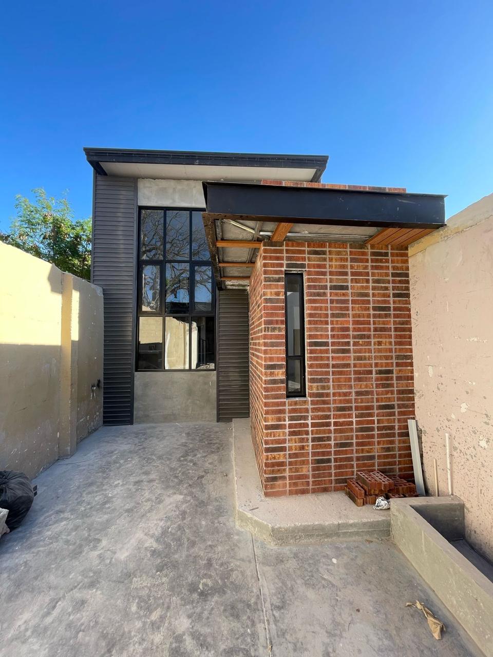 Two-story brick facade with black aluminum window walls by FerMac — 2