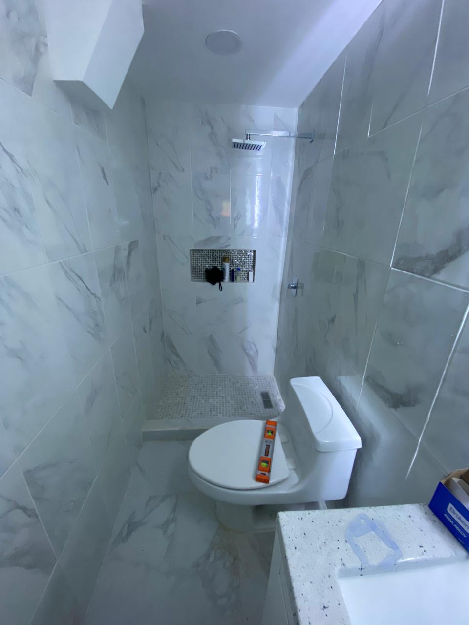 Marble bathroom shower with tempered glass enclosure by FerMac
