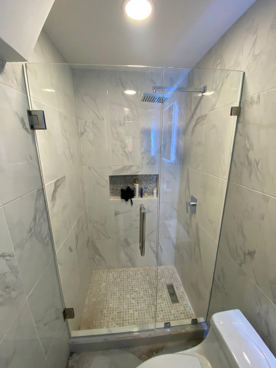 Frameless glass shower enclosure with chrome hardware by FerMac