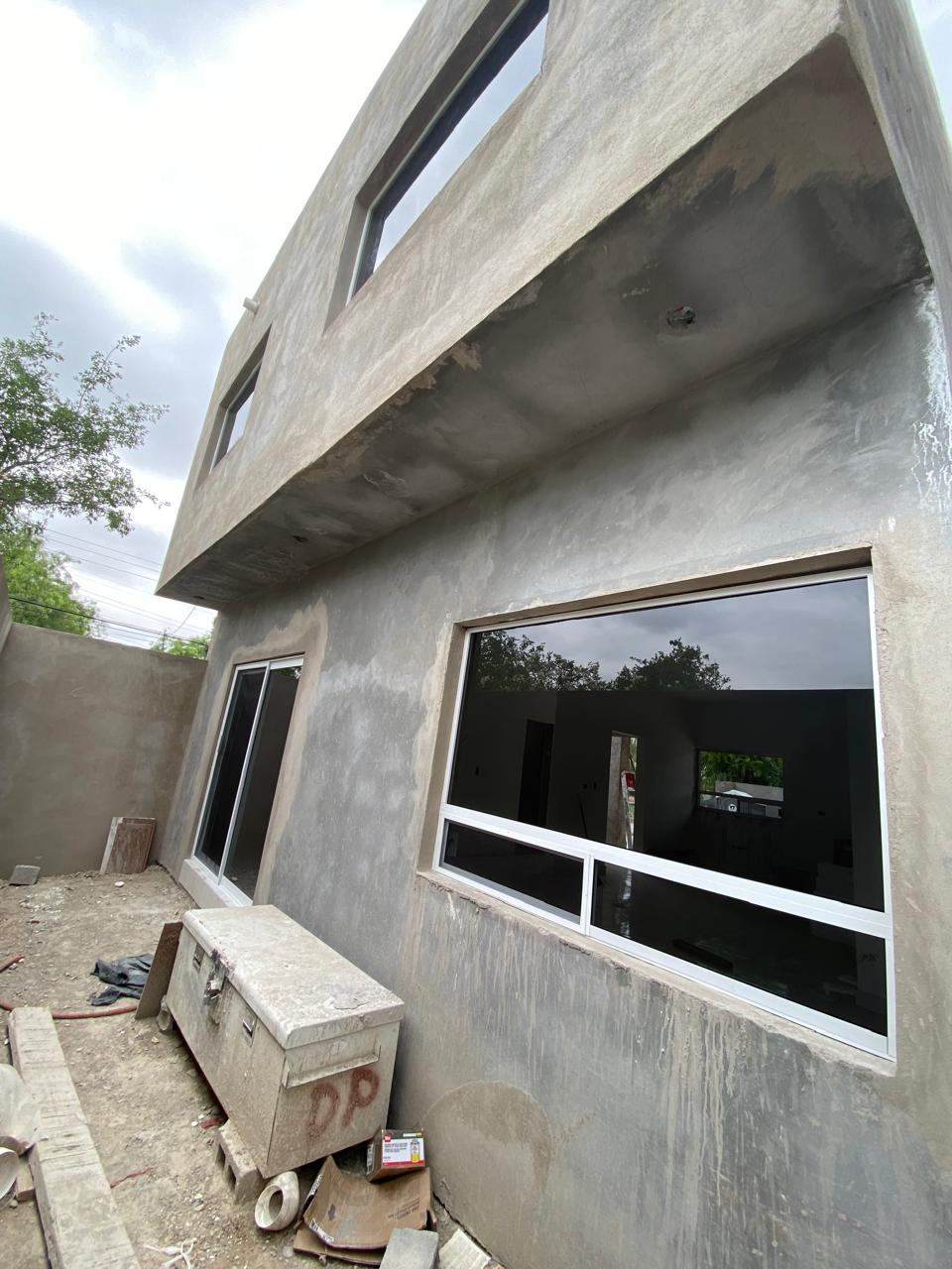 Two-story home with white aluminum tinted windows by FerMac