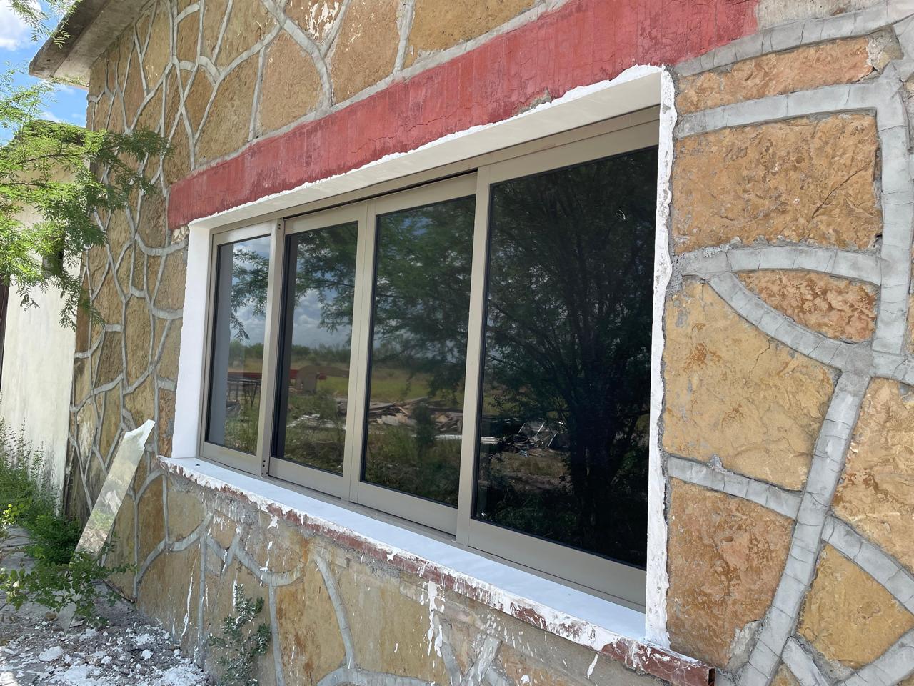 Four-panel sliding aluminum window in a stone wall by FerMac
