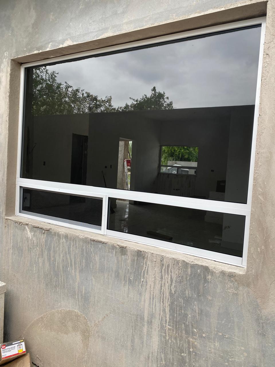 Two-story home with white aluminum tinted windows by FerMac — 2