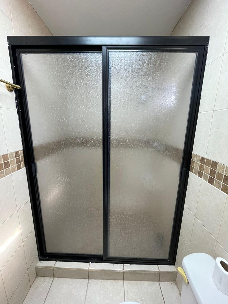 Glass shower enclosure with black aluminum frame by FerMac