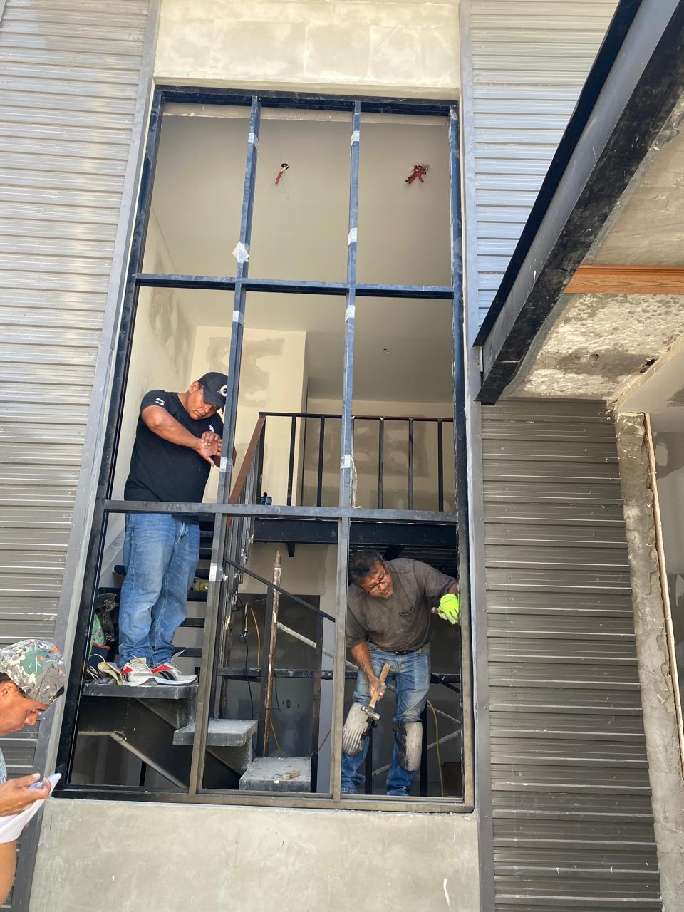 FerMac crew installing a double-height aluminum and glass frame